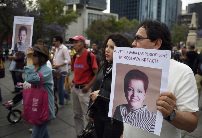 People march during a protest against the recent murder of the correspondent journalist Miroslava Breach, of La Jornada newspaper, at the Angel de la Indepencia in Mexico City, on March 25, 2017. Breach, who investigated drug gangs, was found murdered earlier this week in Chihuahua, northern Mexico near the US border, with multiple gunshot wounds to the head. / AFP PHOTO / ALFREDO ESTRELLA